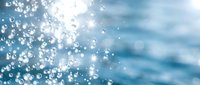 Sparkling water droplets and bokeh light effects on a blue aquatic background, evoking freshness, purity, and summer energy.