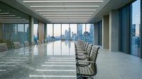 Empty modern conference room with floor-to-ceiling windows overlooking city skyline, marble flooring, and rows of ergonomic chairs along long table for corporate meetings and business presentations.