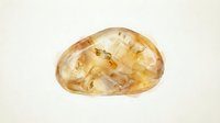 Polished citrine crystal stone isolated on white background, suitable for jewelry design, mineral collection displays, and wellness product packaging.