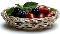 Fresh blackberries and red berries arranged in woven basket with green leaves, suitable for food photography, culinary content, healthy eating promotions and recipe illustrations.