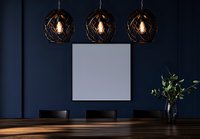 Modern dining room with three spherical black pendant lights above wooden table, blank canvas on navy blue wall, and green plant in vase. Mockup for interior design.
