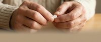 Senior hands holding white pill medication tablet healthcare elderly treatment medicine concept.