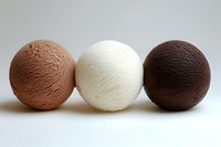 Three scoops of ice cream in chocolate, vanilla, and strawberry flavors arranged in row on white background showing smooth creamy texture and classic neapolitan colors.