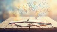 Notebook and pen with floating light bulbs, gears, and question marks representing creative thinking, brainstorming, and problem-solving for business innovation and educational content.