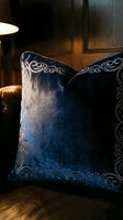 Luxurious navy velvet cushion with ornate silver embroidered borders displayed in warm ambient lighting. Perfect for home decor, interior design, and furniture styling projects.