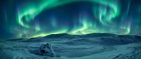Spectacular northern lights aurora borealis dancing across starry night sky over snow-covered arctic landscape with silhouetted figures observing natural phenomenon.