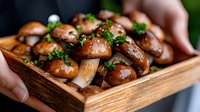 Fresh brown mushrooms garnished with chopped parsley served in rustic wooden box, close up view of organic seasonal fungi. Food photography.