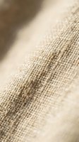 Natural beige linen fabric texture with detailed weave pattern and soft focus background for textile and interior design projects.