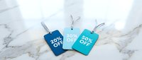 Three colorful discount price tags showing 20, 30 and 50 percent off on a marble surface, retail sale and shopping promotion concept.