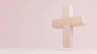 Minimalist wooden cross on soft pink background. Religious symbol with natural wood texture stands upright casting gentle shadow, spiritual concept for faith and worship.