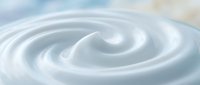 Creamy white swirl pattern with smooth flowing curves creating elegant spiral motion on soft pastel background for dairy and cosmetic product designs.
