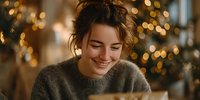 Young woman smiling while reading a book during holiday season with warm Christmas lights bokeh in background. Cozy winter atmosphere.
