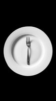 Elegant white dinner plate with black fork centered on transparent background, ready for restaurant menus, dining designs, culinary graphics, print-on-demand products, and food service marketing materials.