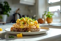 Scrambled eggs with fresh herbs on multigrain toast served on white plate in bright modern kitchen. Healthy breakfast meal ready to eat.