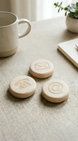 Wooden contact icons with envelope, phone, and email symbols on linen desk surface next to ceramic mug and potted plant for business communication design.