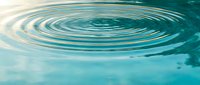 Concentric water ripples spreading across calm turquoise surface creating peaceful zen meditation atmosphere for wellness and relaxation concepts.