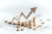 Growing stacks of gold coins with upward trending metallic arrow on financial report background, representing investment growth and profit increase.