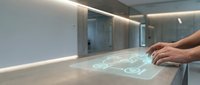 Hands interacting with holographic interface displaying digital icons on transparent surface in modern office space with minimalist design.