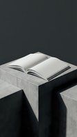 Open book with blank pages on concrete table against dark background for minimalist design projects and educational content.