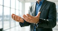 Professional businessman in suit with open hands gesture presenting concept in modern office environment for business presentations and corporate communications.