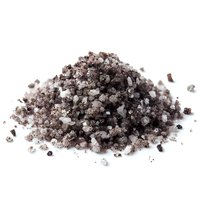 Pile of black salt crystals mixed with white salt on white background, used in gourmet cooking and as a finishing garnish.