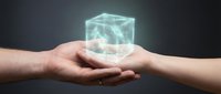 Hands exchanging glowing digital cube with holographic data visualization, representing technology transfer, innovation sharing, and business collaboration in modern digital environment.