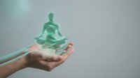 Holographic meditation figure floating above open hands representing mindfulness, wellness technology, spiritual guidance, and digital health solutions.