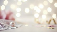Soft romantic bokeh background with delicate lace fabric and warm golden lights creating dreamy atmosphere for wedding or Valentine's Day designs.