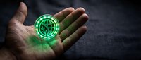 Male hand holding glowing green holographic digital interface symbol with futuristic technology design on dark textured background for modern tech concepts.