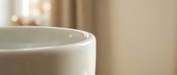 White ceramic coffee mug close-up with soft bokeh background creating warm morning atmosphere for kitchen and cafe concepts.