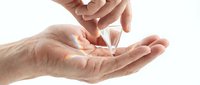 Hand sanitizer gel being dispensed into cupped palms for hygiene and cleanliness against white background isolated for design use.