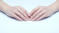 Two hands forming heart shape gesture on white background expressing love care and affection for romantic wellness concepts.
