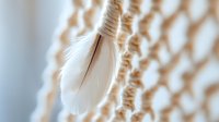 Delicate white feather hanging from natural jute rope against soft blurred background creating peaceful minimalist composition for wellness and meditation themes.
