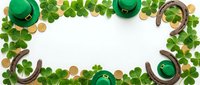 St Patricks Day frame with green leprechaun hats, shamrock leaves, horseshoes and gold coins on white background for festive holiday decorations.