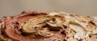 Swirled chocolate and caramel frosting with rich creamy texture for dessert decoration and baking projects.