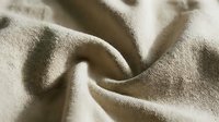 Neutral beige linen fabric with soft folds and natural texture, suitable for textile design, fashion backgrounds, and interior decor projects.