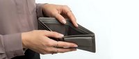 Empty wallet in hands showing financial crisis and money problems concept for budgeting and economic hardship situations.