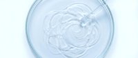 Clear moisturizing gel cream with glass stirring rod in petri dish for skincare cosmetic research and laboratory testing applications.