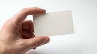 Male hand holding blank white business card isolated on white background, ready for custom branding and corporate identity design.