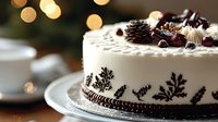 Elegant winter cake decorated with pine cones, chocolate curls and delicate snowflake patterns on white frosting, festive bokeh lights in background.