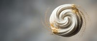 Elegant white cream swirl with golden glitter particles on soft gray background for luxury cosmetics and beauty product design.
