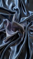 Luxurious dark gray silk fabric with elegant folds and waves creating smooth flowing texture. Abstract background for fashion and luxury design projects.