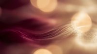 Silky strands of burgundy and golden hair flowing with soft bokeh light effects, suitable for beauty, haircare, and cosmetics marketing materials.