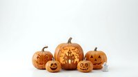 Carved jack-o-lantern pumpkins with glowing faces and haunted house design isolated on white background for Halloween decorations and seasonal marketing.