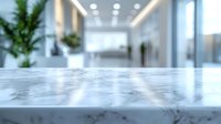 Modern marble countertop surface in blurred contemporary office lobby with plants and bright lighting for product display and commercial presentations.