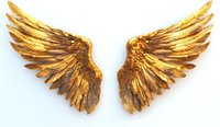 Golden angel wings spread wide against white background, metallic feathered pair with detailed texture and rich bronze highlights, isolated design element.
