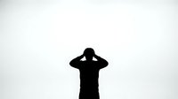 Silhouette of person holding head in hands expressing stress, depression or mental health struggles against white background for design projects.
