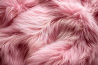 Luxurious pink faux fur texture background with soft fluffy fibers creating waves and shadows. Closeup macro photography of artificial plush fabric surface.