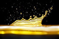 Golden liquid crown splash with droplets against black background, high-speed macro photography capturing dynamic fluid motion and surface tension in yellow liquid.