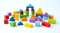 Colorful wooden building blocks set with geometric shapes including cubes, triangles, cylinders and rectangles for educational play and development.